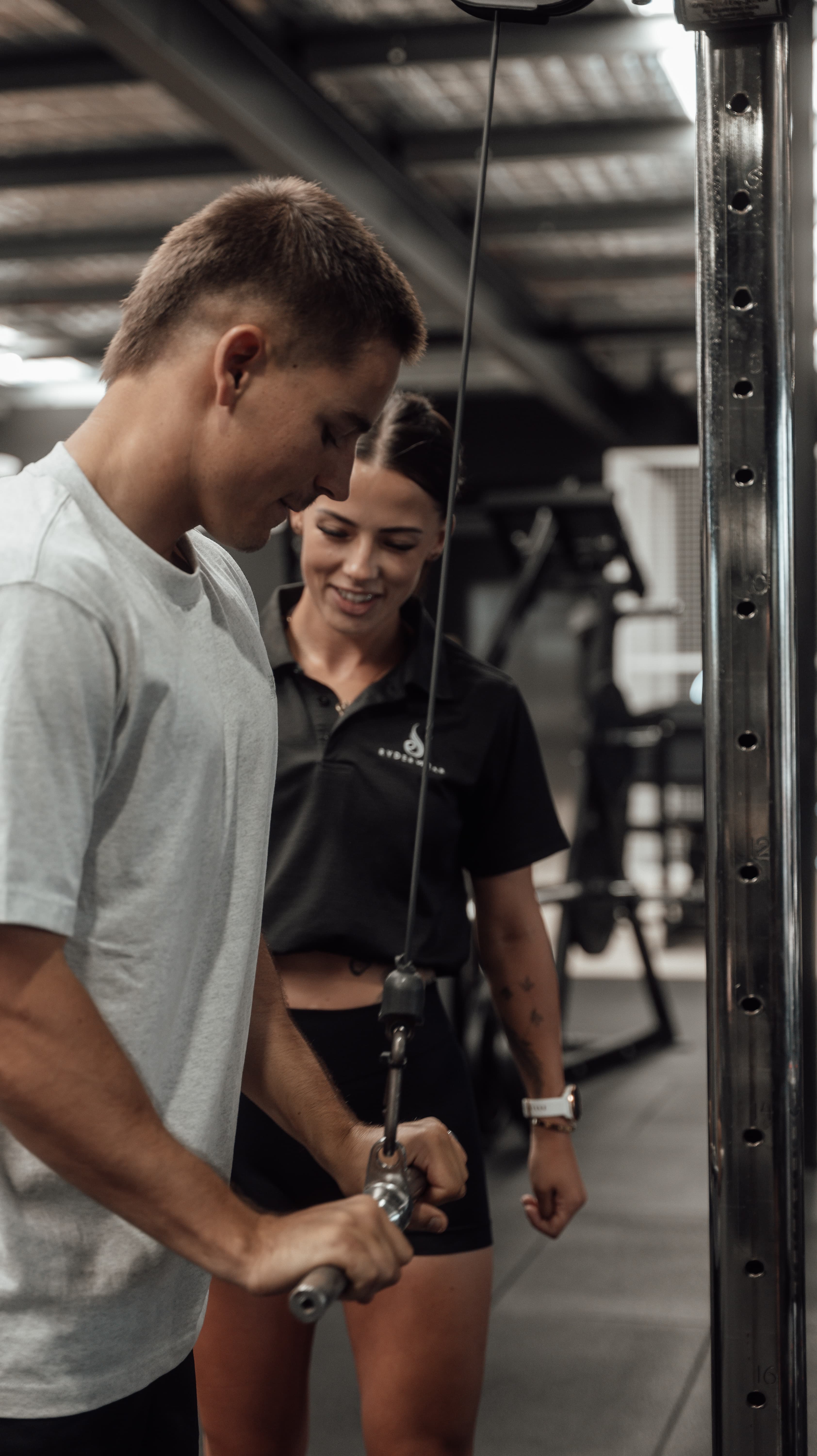 Female personal trainer Samantha Hobley coaching a client through proper form